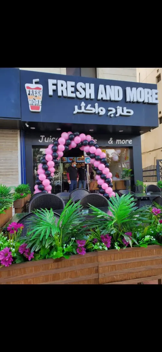 قوس بالونات وردي وأسود لمدخل محل