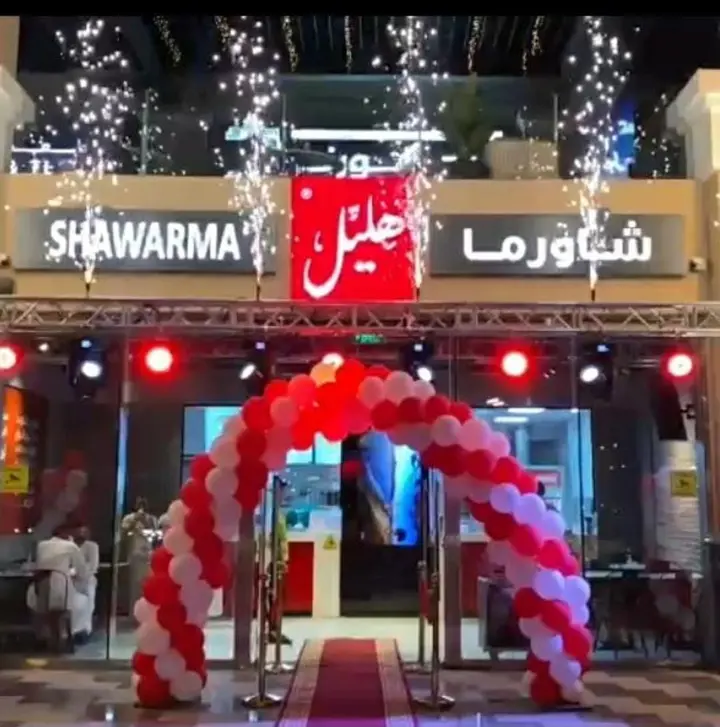 قوس بالونات أحمر وأبيض مع تراس افتتاح